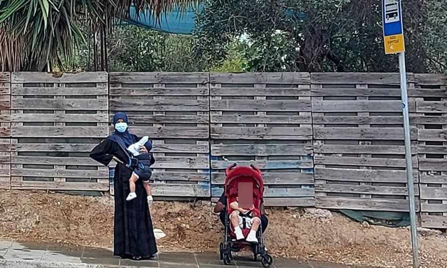 Μάνα με βρέφη περιμένουν λεωφορείο στη βροχή